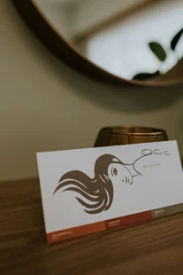 Kaartje met het Bonito-logo op een houten tafel, met een ronde spiegel erachter