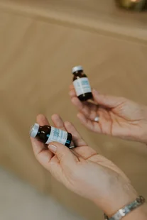 Handen houden twee flesjes serum vast