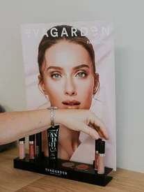EVAGARDEN Fantastica toonbankdisplay met lipglossen, serum en oogschaduw op een houten tafel in Schoonheidsinstituut Bonito Melsele.