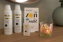 Zonneproducten naast een glas en droogbloemen op een tafel