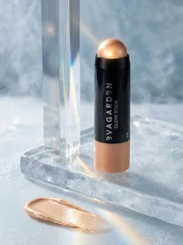 De EVAGARDEN Glow Stick highlighter in de tint Pearly Glow geopend op een ijzige, reflecterende achtergrond.
