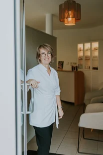 Wendy in de deuropening van het schoonheidsinstituut, met productrekken naast haar