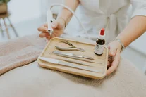 Houten schaaltje met instrumenten op een handdoek tijdens een handverzorging