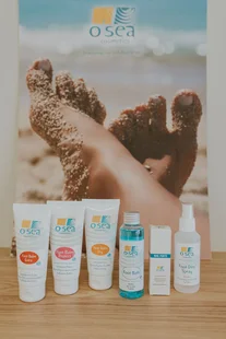 Zonneproducten van O'SEA voor een poster met voeten in het zand