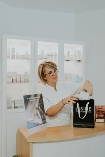 Wendy met een LISINE-cadeautas in de verkoopruimte van het instituut